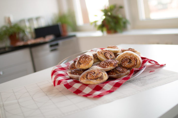 Kanelbullar på fat med rutig bakrut under.