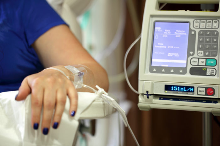 Cancersjuk kvinna får dropp i armen.